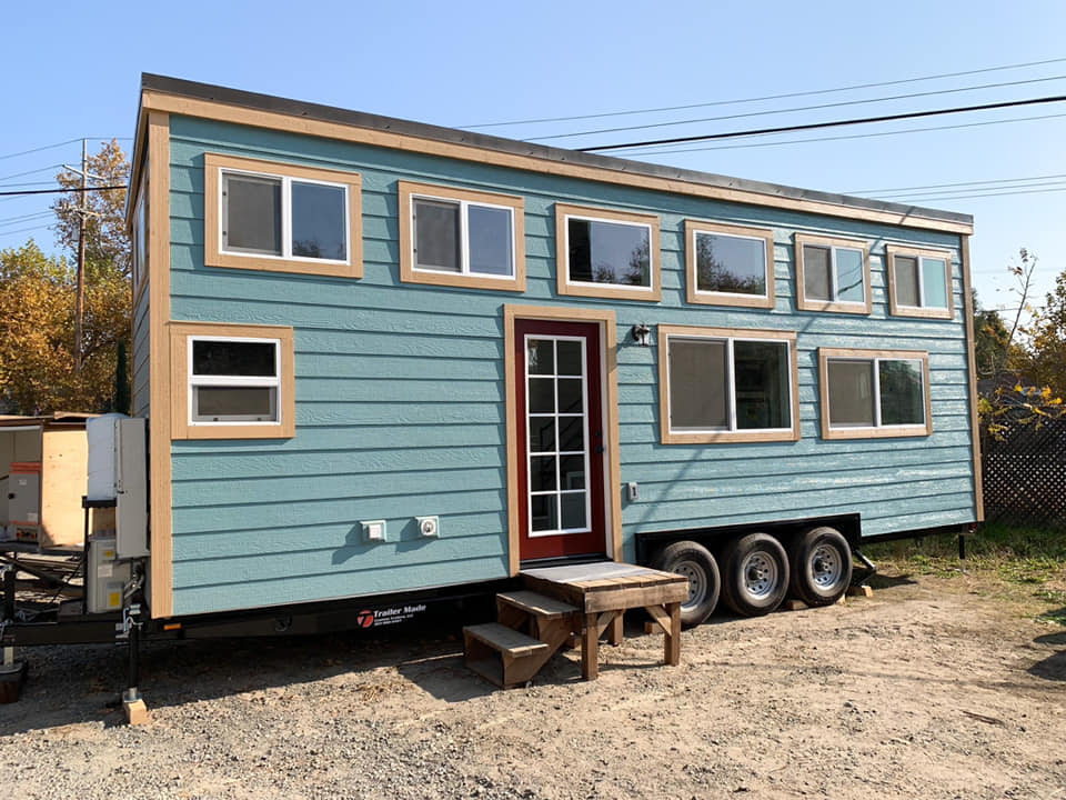 Blue tiny home on wheels with upper clerestory windows
